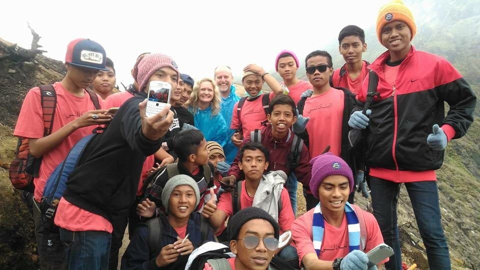Climbing the Amazing Ijen Volcano in Java to watch the sunrise 5 Photos of group of Indonesian travellers wearing pink and black jackets with Larch and Alan wearing blue on Ijen Volcano