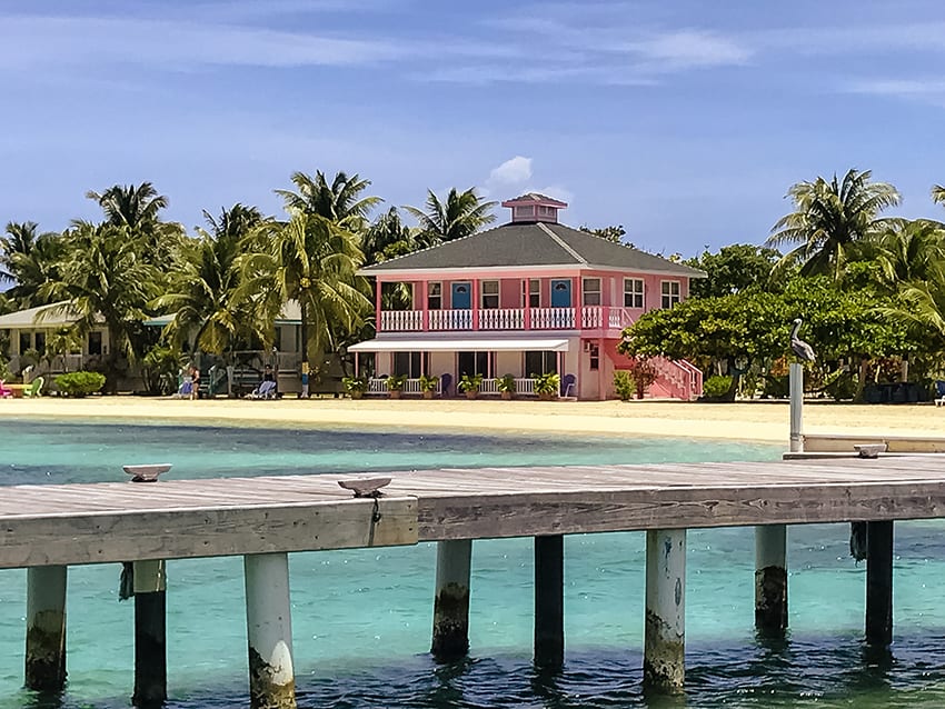 6 of the Best Places to Stay in Guanaja, Honduras 7 Graham's Place in Guanaja with candy pink house, palm trees white beach