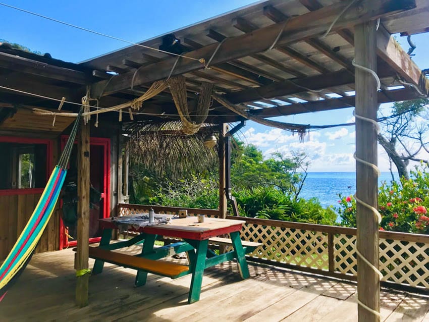 6 of the Best Places to Stay in Guanaja, Honduras 4 Guanaja Backpackers Hostel with views over the sea from the shaded colourful hammock and table and bench seating