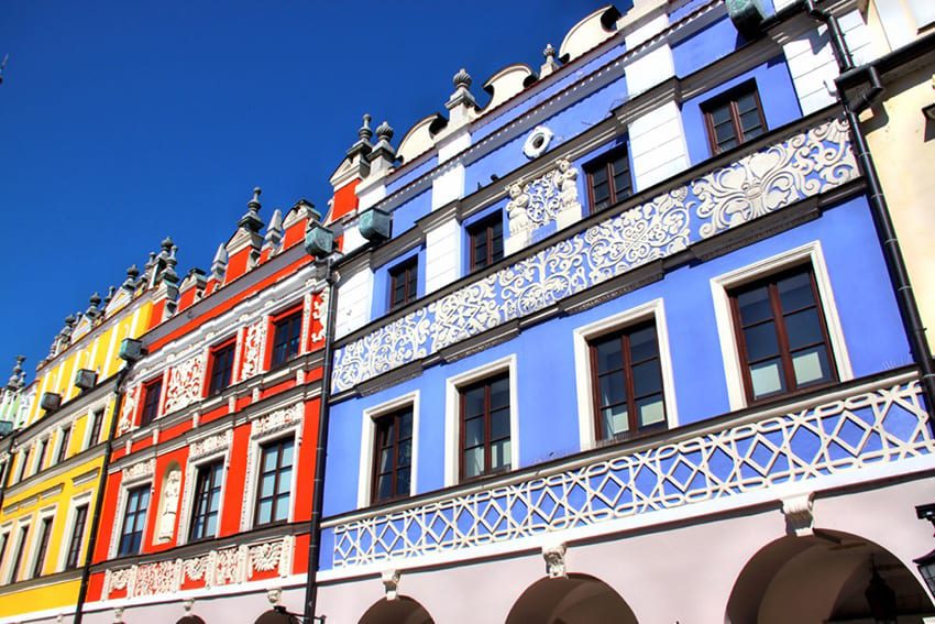 23 Amazing Unesco Sites In Europe, Off The Beaten Track 10 Colourful Tenemnet houses in Zamosc Poland with blue, red and yellow painted facades