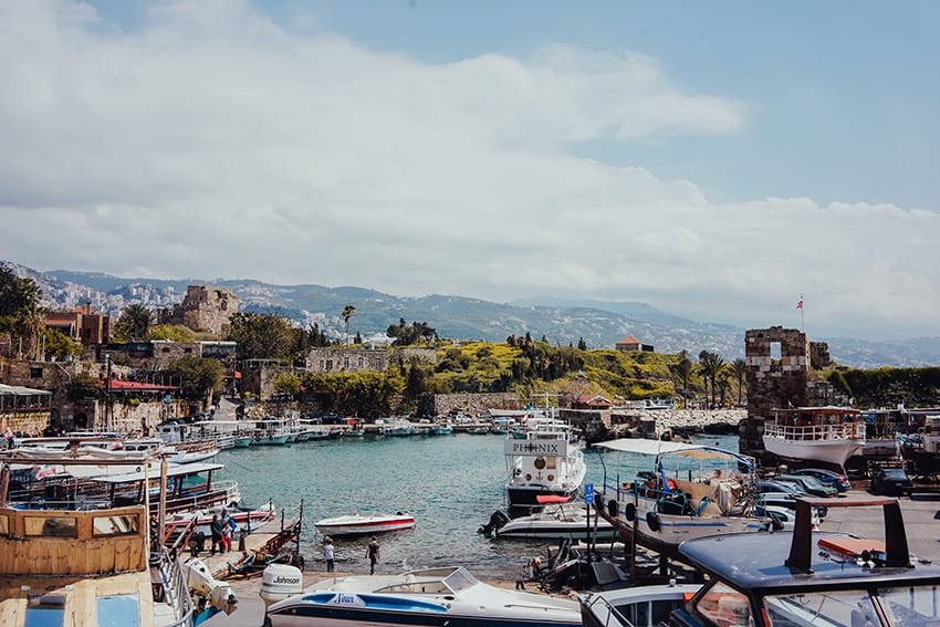 8 Amazing UNESCO Sites in The Middle East - Off the Beaten Track 9 The harbour at Bylbos with river boats in the the foreground and the town on the green hill in the mid ground and hills in the back ground. It is a sunny day