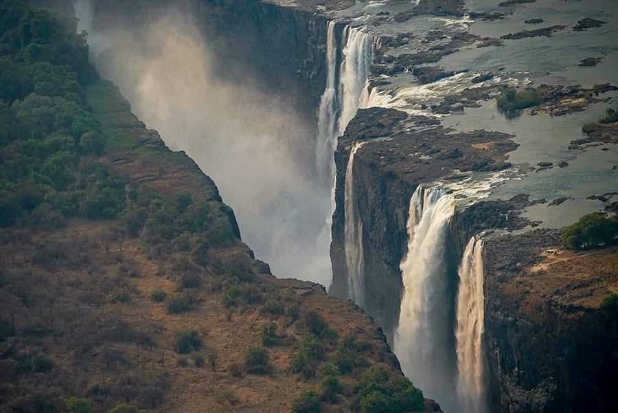 12 Amazing Unesco Heritage Sites In Africa - Off The Beaten Track 11 Victoria Falls - waterfalls with spray coming up between the two sides of land