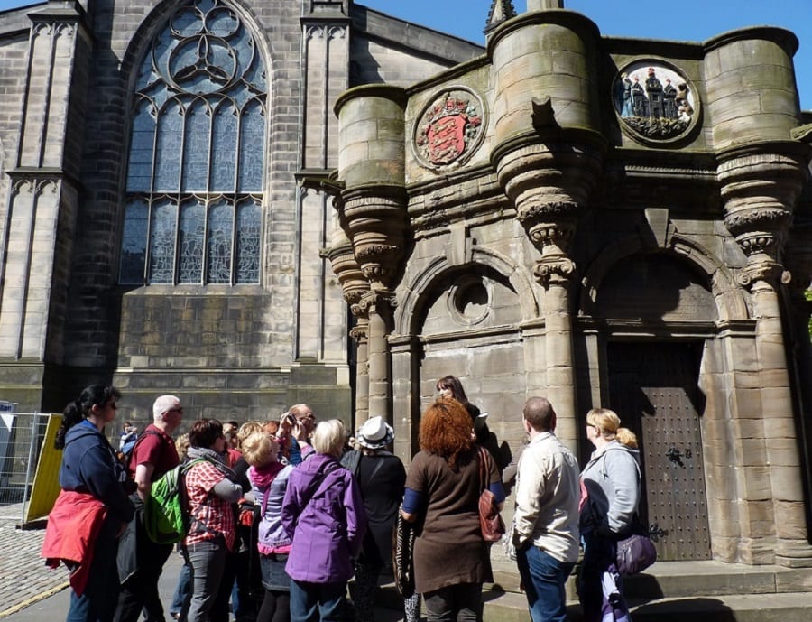 A group of people standing outside Scottish Church in Edinburg - a great solo travel tip for meeting people