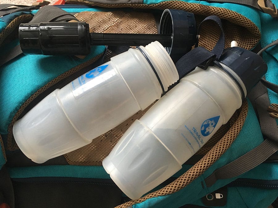 two opaque water bottles with filters -  great solo travel tips