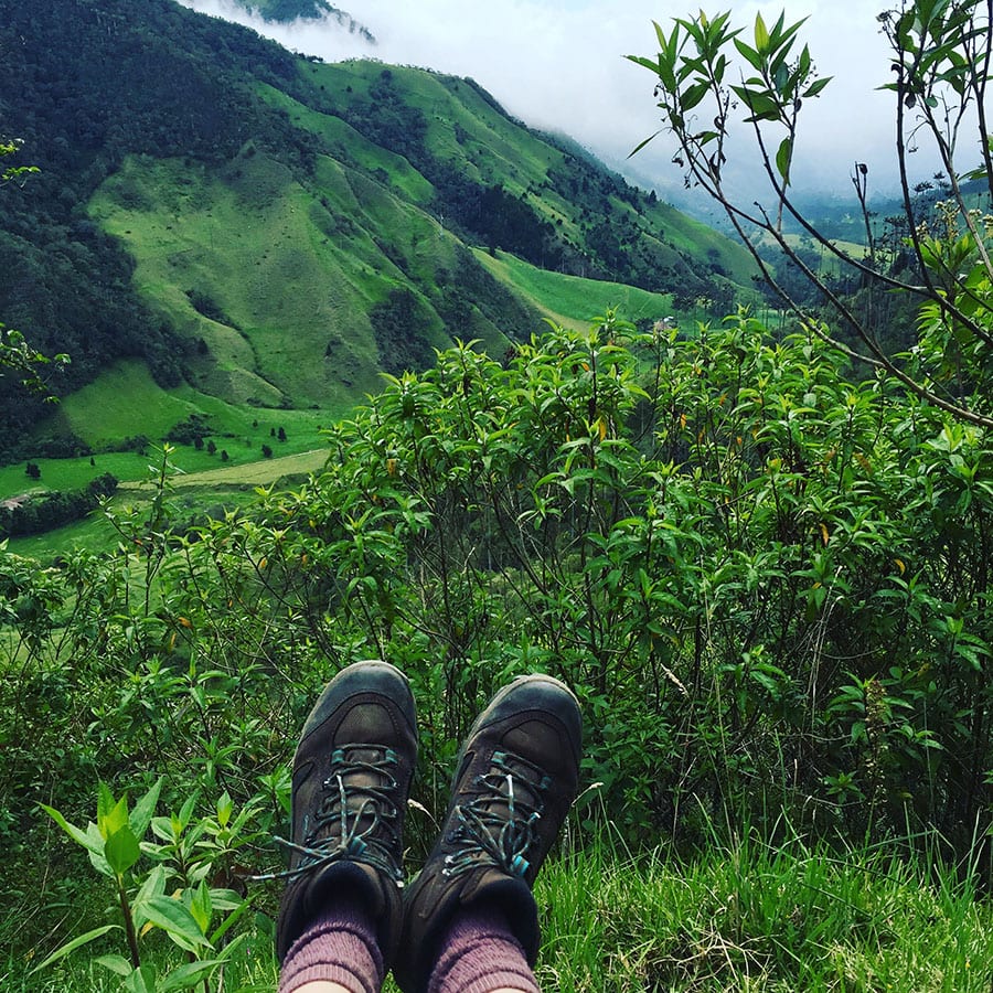 pair of boots against a background of lush green hills