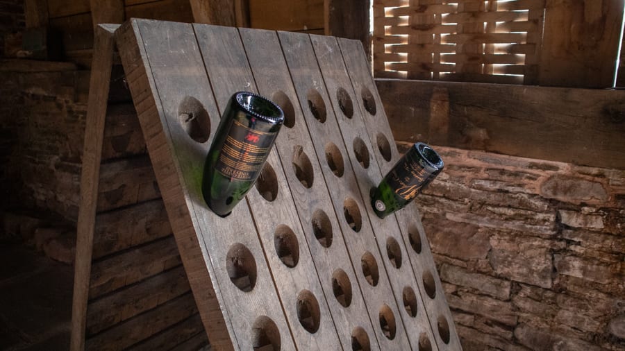 White Castle Vineyard - Tasting Delicious Award Winning Welsh Wines 4 two empty bottles of sparkling wine stored in a wooden bottle holder