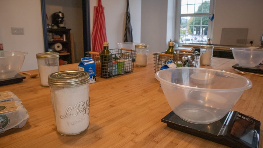 Artisan Bread Baking at the Abergavenny Baker 4 wooden table with scales, bowls and ingredients for baking
