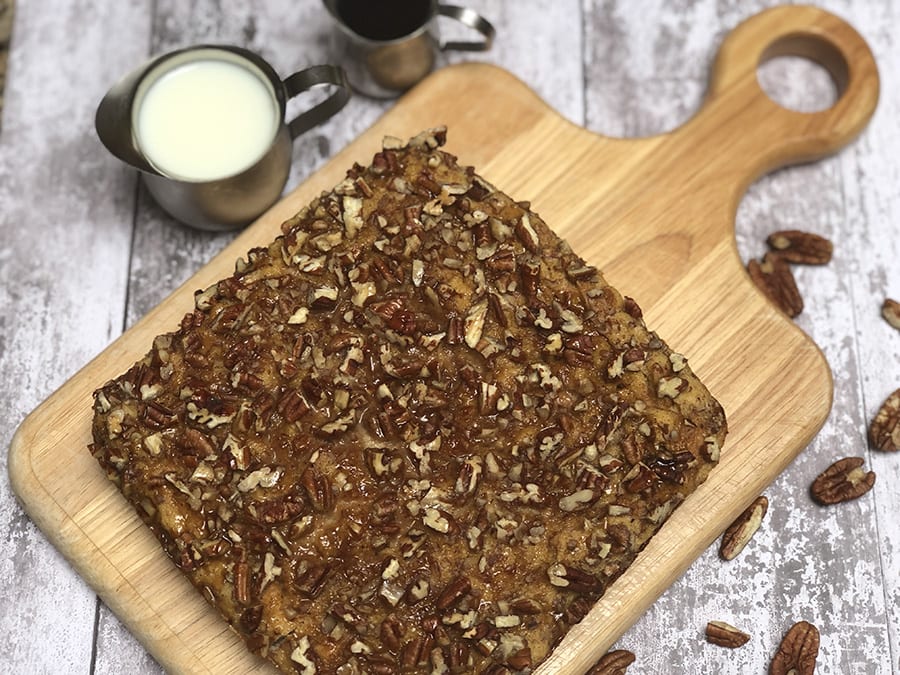 Favourite Christmas Bakes to try this year 8 wooden board with square of brown french toast covered in pecans with pecans around - Chef Denise's Favourite Christmas bake for Breakfast