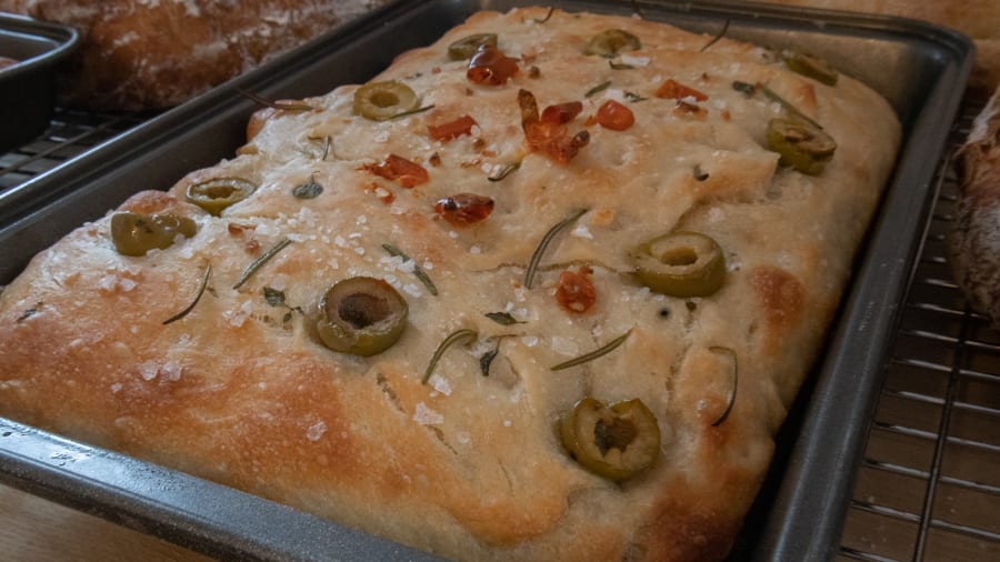 Artisan Bread Baking at the Abergavenny Baker 7 rectangle cooked bread topped with olives, rosemary, salt and sundried tomatoes
