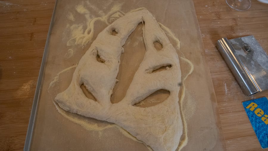 Artisan Bread Baking at the Abergavenny Baker 6 uncooked dow in a triangle shape with a long gap in the middle and three cut holes on either side