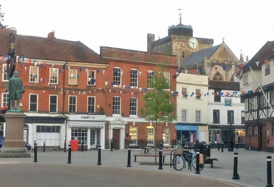 6 Of The Best Weekends In Hampshire, Uk 4 Market square with a Romsey Abbey in the background. There is blue, red and white bunting between the buildings