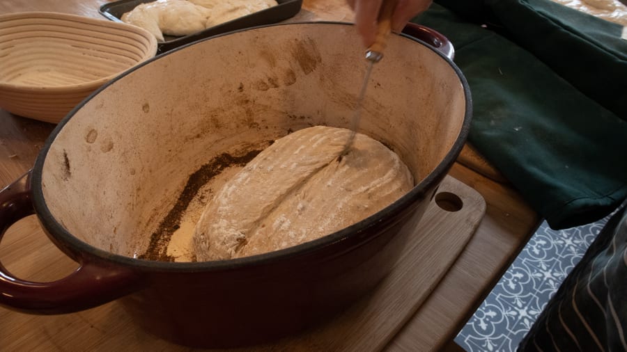 Artisan Bread Baking at the Abergavenny Baker 9 dough in a double oven with a lame knife scoring the top