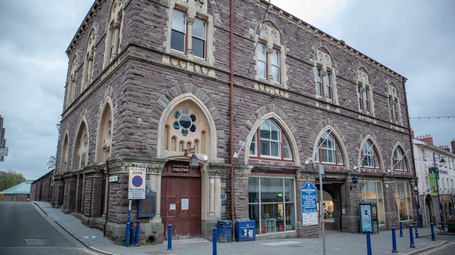 Square market building with arched windows on first floor