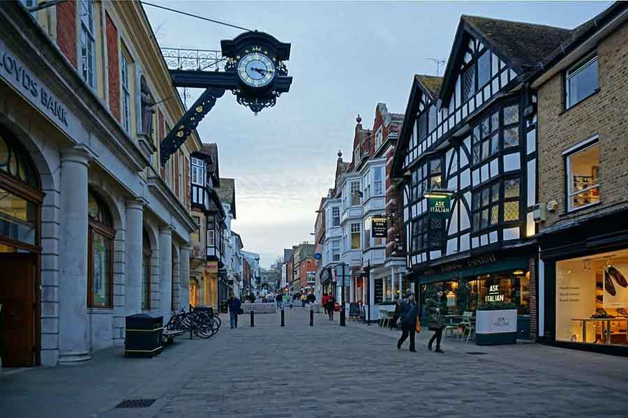 6 Of The Best Weekends In Hampshire, Uk 2 street with Tudor black and white building on the right and an ornate black and gold clock