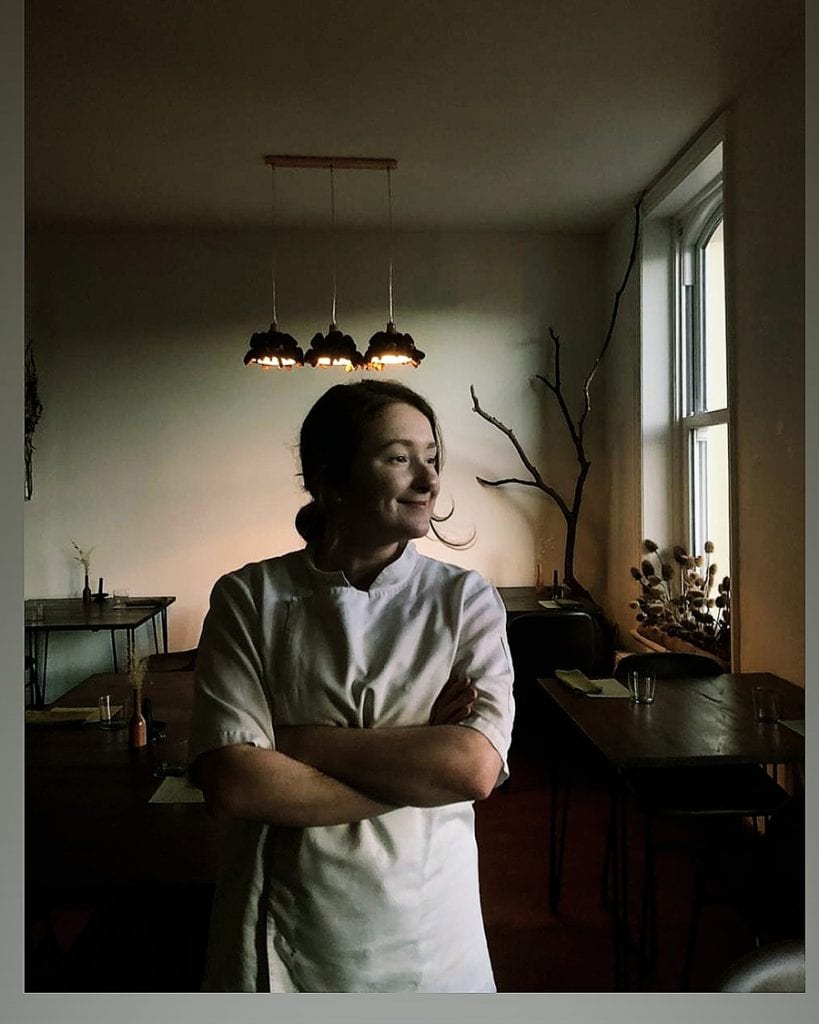 Versa - Responsibly Sourced Dining On The Isle Of Man 2 Woman standing in chef whites with tables and chairs in background