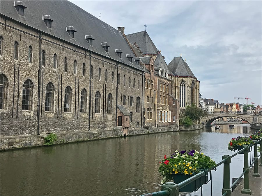 35+ Amazing Hidden Gems In Europe You Must Visit 20 Canal with warehouses in Ghent with flowers baskets on the railings