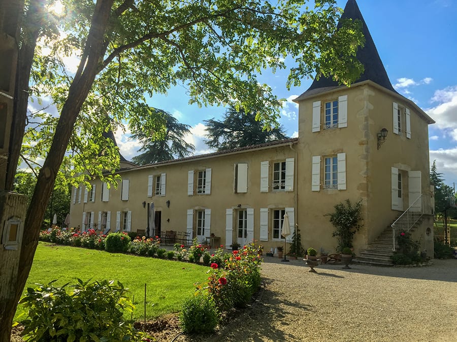 35+ Amazing Hidden Gems In Europe You Must Visit 15 Les Bruhasses cream long building with white shutters and square turrets