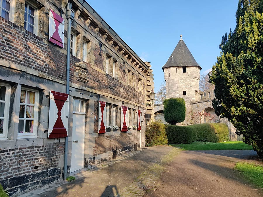 35+ Amazing Hidden Gems In Europe You Must Visit 17 view of old buildings with red and white painted shutters and tower