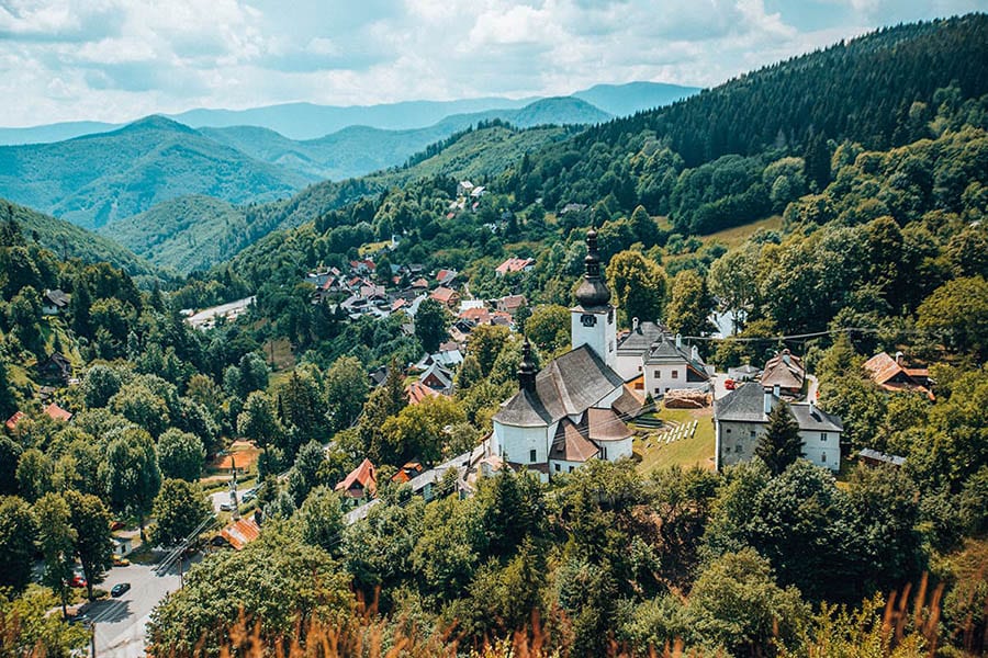 35+ Amazing Hidden Gems In Europe You Must Visit 22 view down a wooded valley with a the roofs of the village of Spania Dolina in the foreground