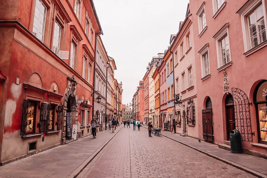 35+ Amazing Hidden Gems In Europe You Must Visit 18 a long street with burnt sienna coloured houses and cobbles on the streets