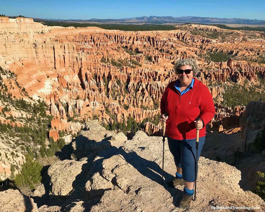 Celebrating 16 Awesome Mature Bloggers In 2021 To Inspire You 3 Linda from Retired and Travelling wearing a red sweatshirt and blue trousers with the Bryce Canyon National Park Viewpoints behind her