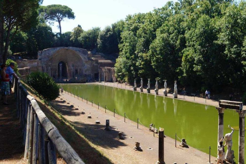 Stunning UNESCO Sites in Italy to discover in 2023 16 Villa Adriana Canopus - long rectangular pond with ancient statues around it and an arched building at the end
