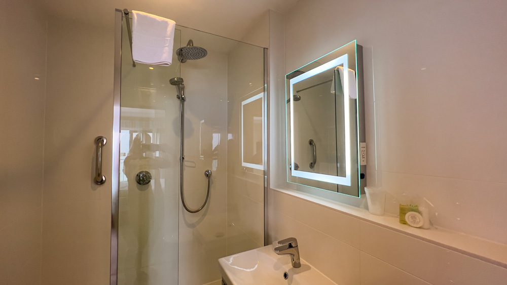 Visiting The Beautiful Biarritz Hotel In Jersey, Channel Islands (2023) 6 The bathroom of Superior Sea View with digital shower, mirror with lighting. On the shelf are complimentary toiletries