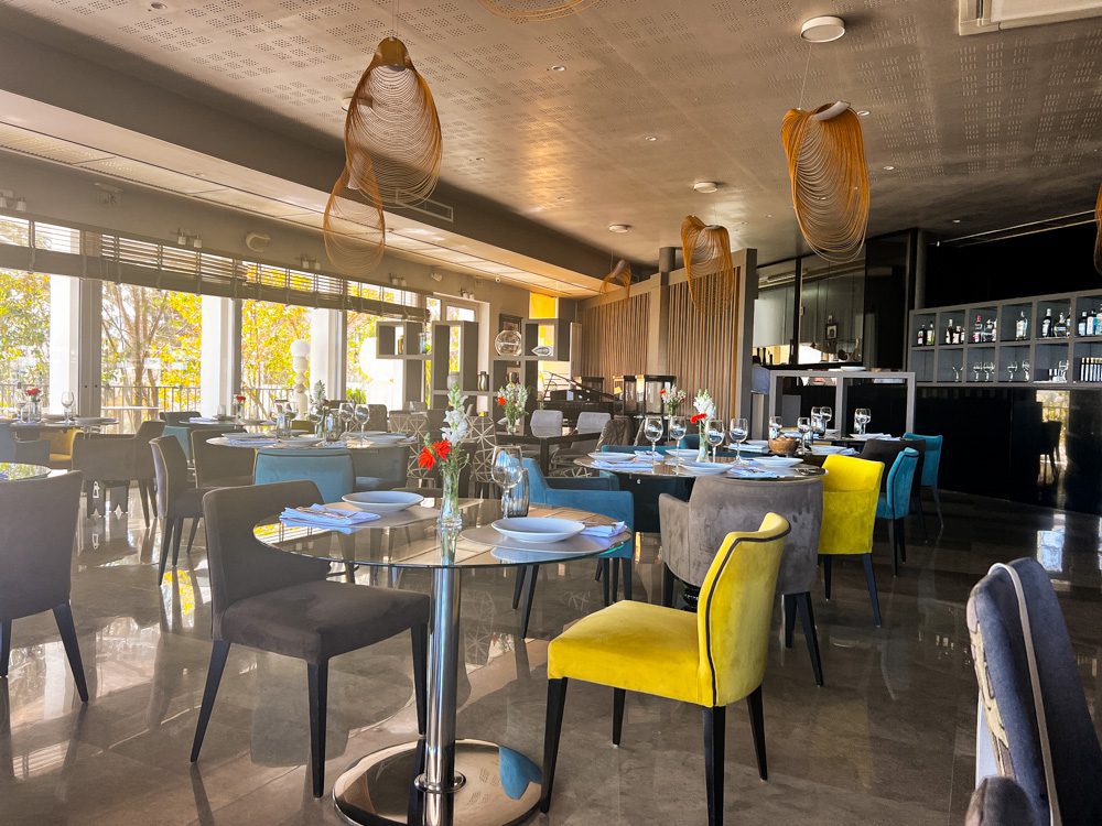 Sawa Taste of Tunisia: Explore the amazing food of Tunisia (2024) 53 Inside the RestÔ with yellow, grey and blue chairs and glass tables