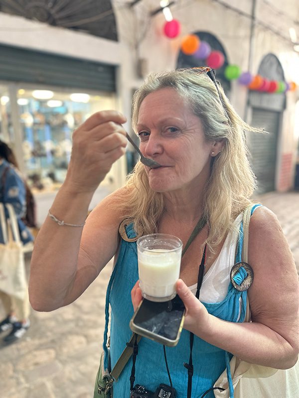 Sawa Taste of Tunisia: Explore the amazing food of Tunisia (2024) 33 Larch in a turquoise dress trying the fermented milk