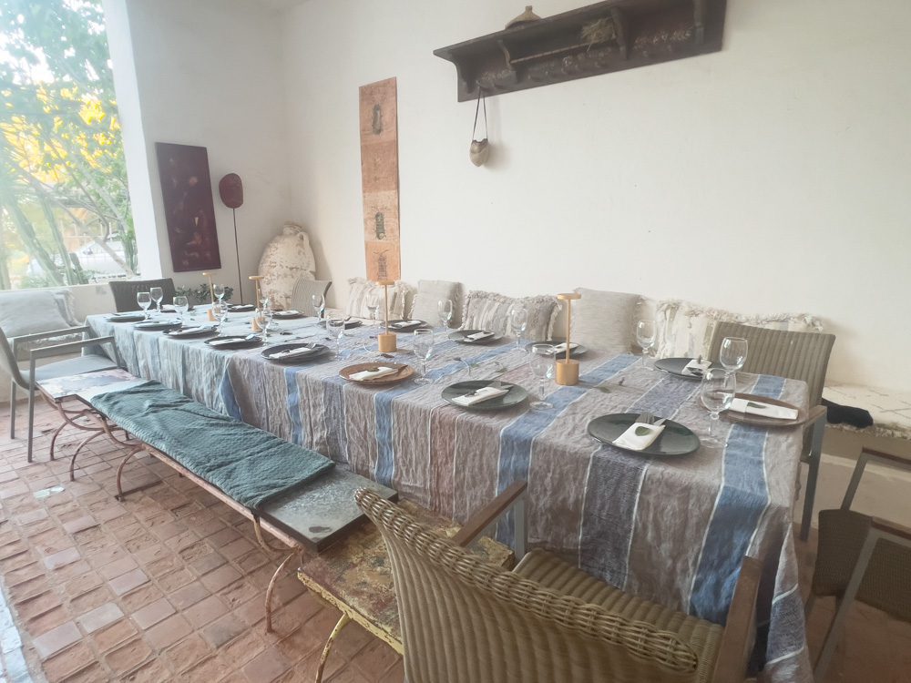 Sawa Taste of Tunisia: Explore the amazing food of Tunisia (2024) 57 long table with grey and blue striped tablecloth set with plates and glasses