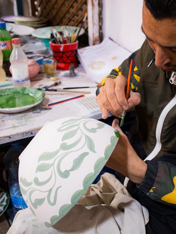 Sawa Taste of Tunisia: Explore the amazing food of Tunisia (2024) 13 man painting a white bowl with green paint in a floral pattern