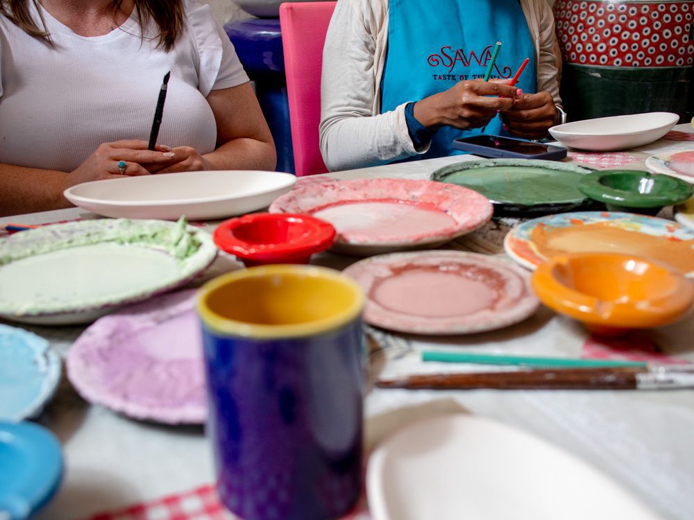 Sawa Taste of Tunisia: Explore the amazing food of Tunisia (2024) 11 colourful plates with paint on them