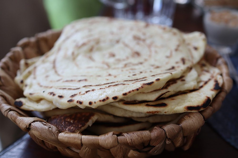 Sawa Taste of Tunisia: Explore the amazing food of Tunisia (2024) 6 a bowl of cooked mwali, round disc of flatbreads in a wicker bowl