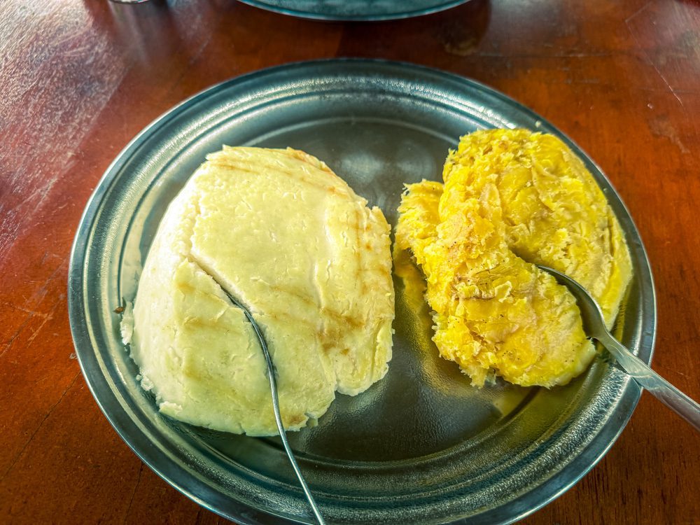 What to eat in Uganda? Posho and Matooke on a silver plate with spoons.